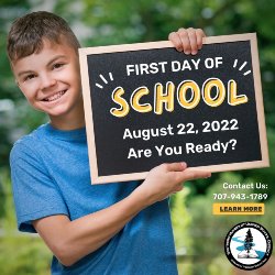 School Age Boy in Blue tshirt holding a chalk board sign \"First Day of School\" 